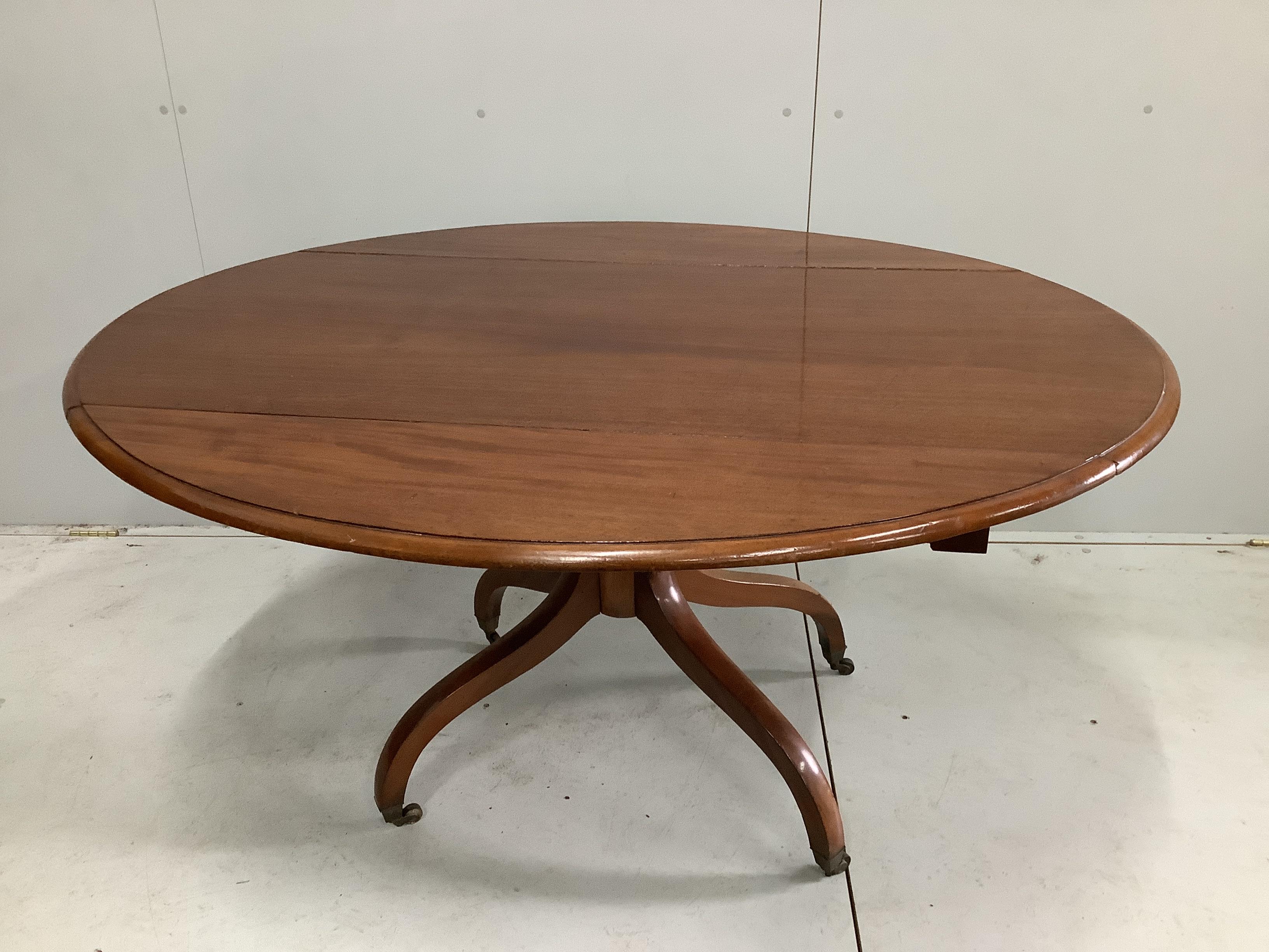 A Regency mahogany oval drop leaf dining table, width 140cm, depth 64cm, height 73cm